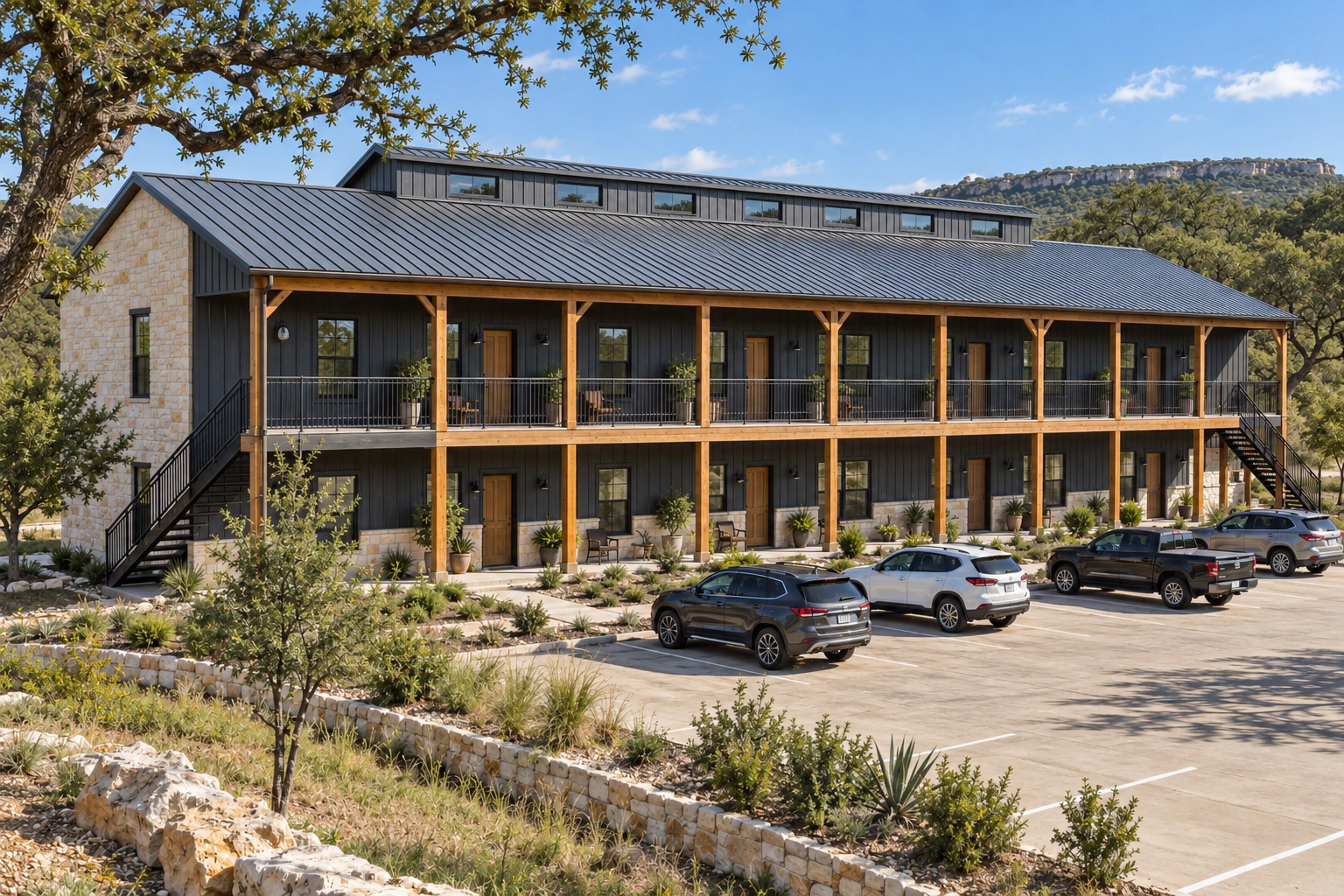 Large two-story multifamily metal barndominium with multiple private entrances, a covered upper walkway, and shared resident parking