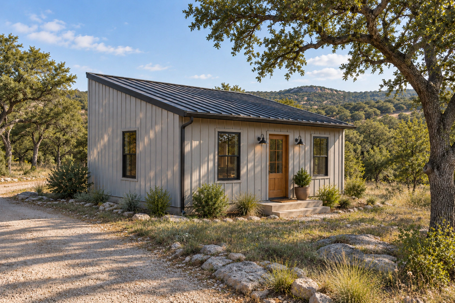 Tiny barndominium with one continuous single-slope metal roof on a natural Texas Hill Country property